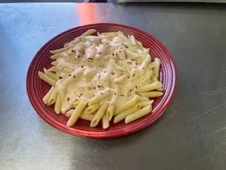 A red plate with some pasta on it